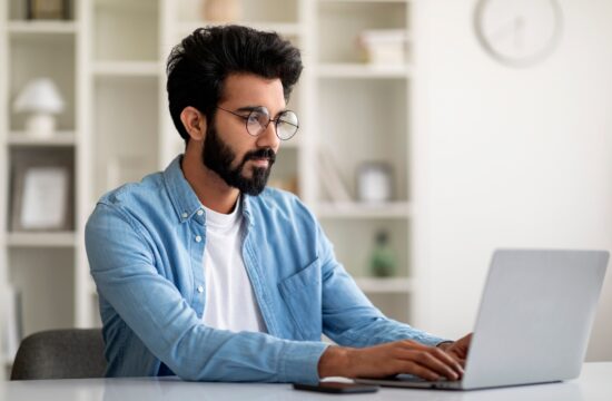 Freelance Work. Handsome Young Indian Man Working On Computer At Home Office