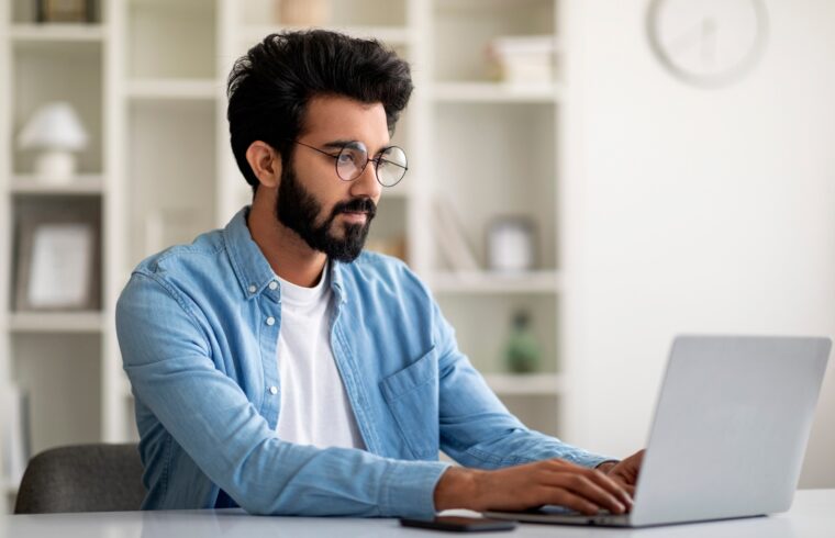 Freelance Work. Handsome Young Indian Man Working On Computer At Home Office