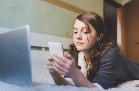 young woman indoor bedroom using smartphone