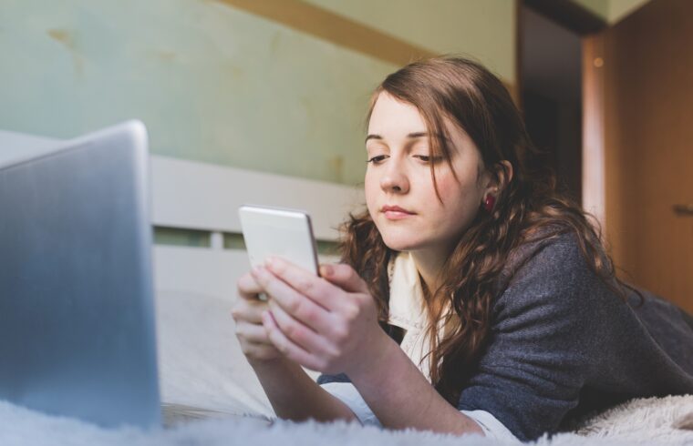 young woman indoor bedroom using smartphone
